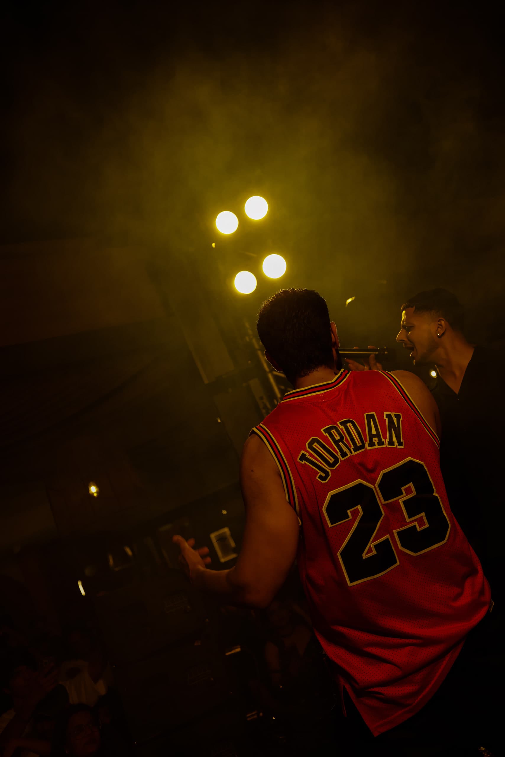 Seen from behind, the number across the jersey against an orange haze
