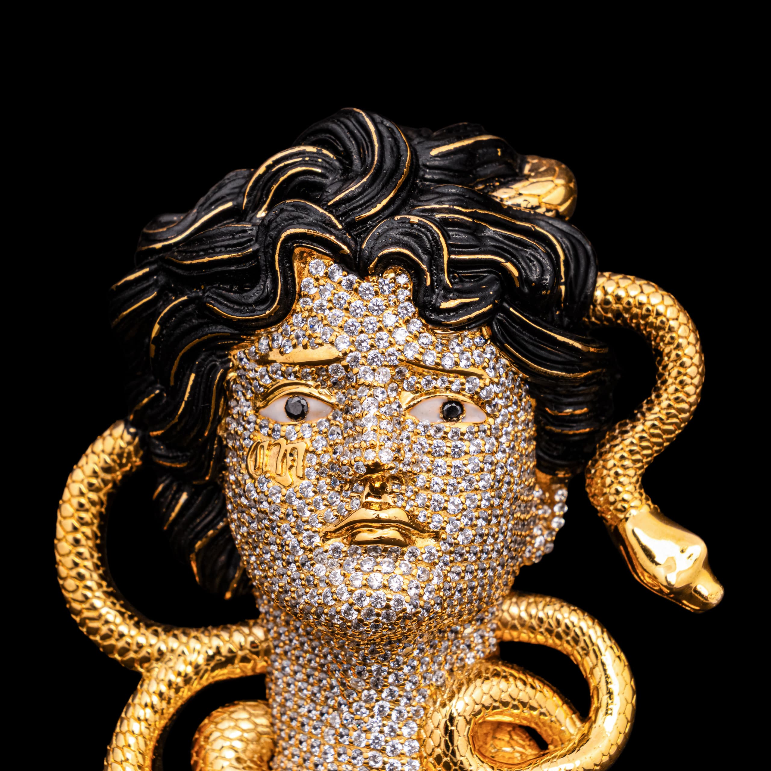 Medusa brooch: a stone-set face under black enamel curls, gold snakes coiling out of the hair