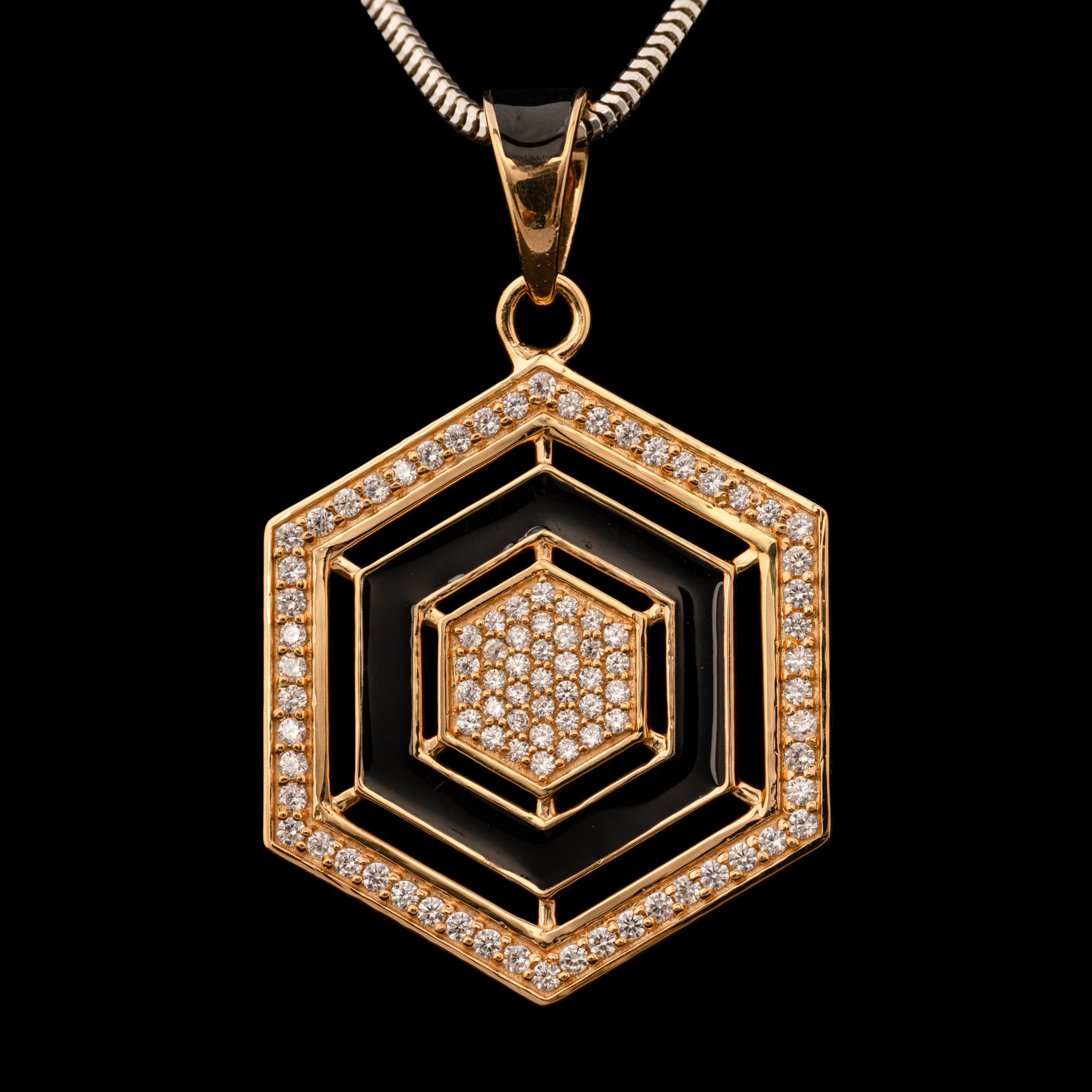 Hexagonal gold pendant on a snake chain, a diamond honeycomb at its centre