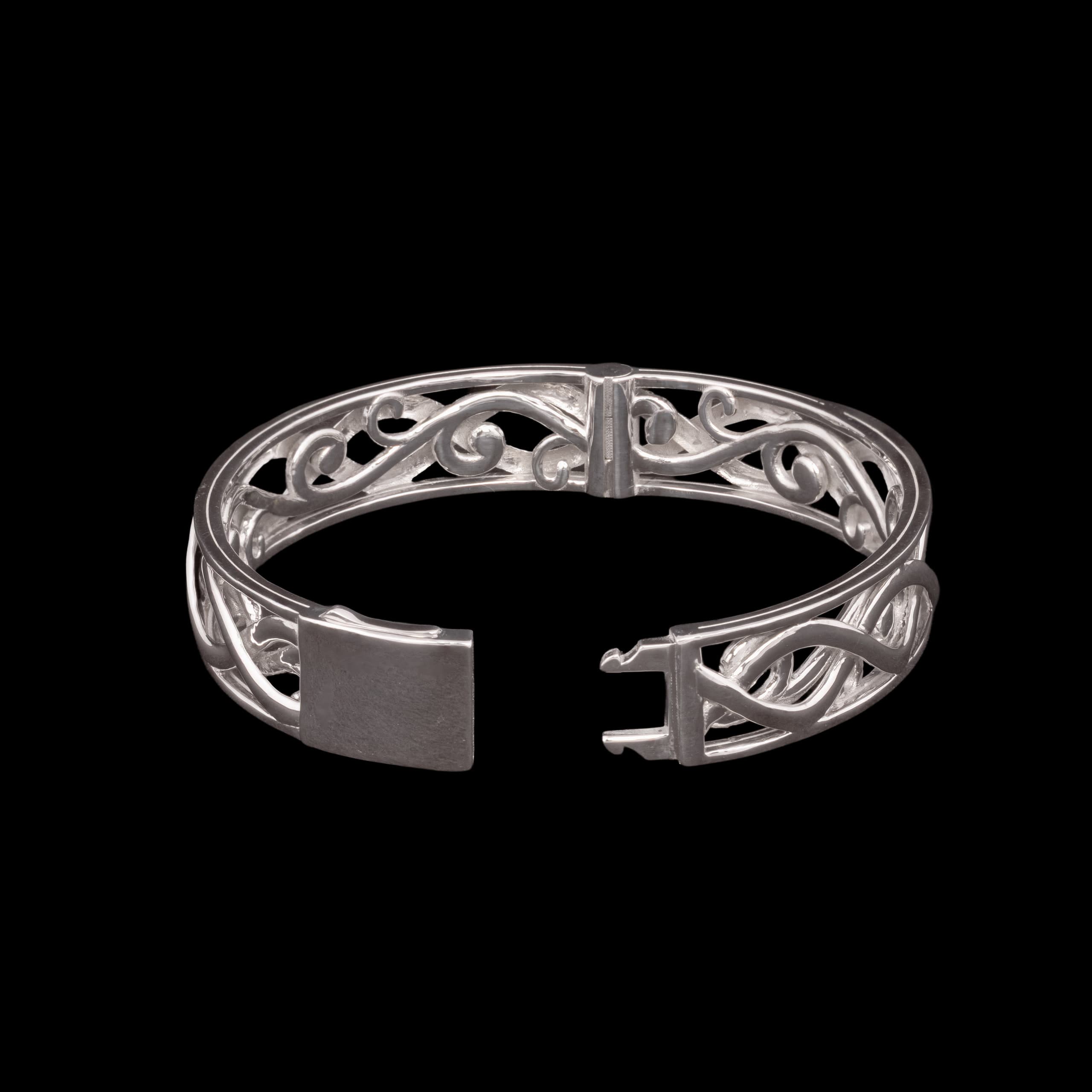 Open silver cuff with filigree scrollwork along its face