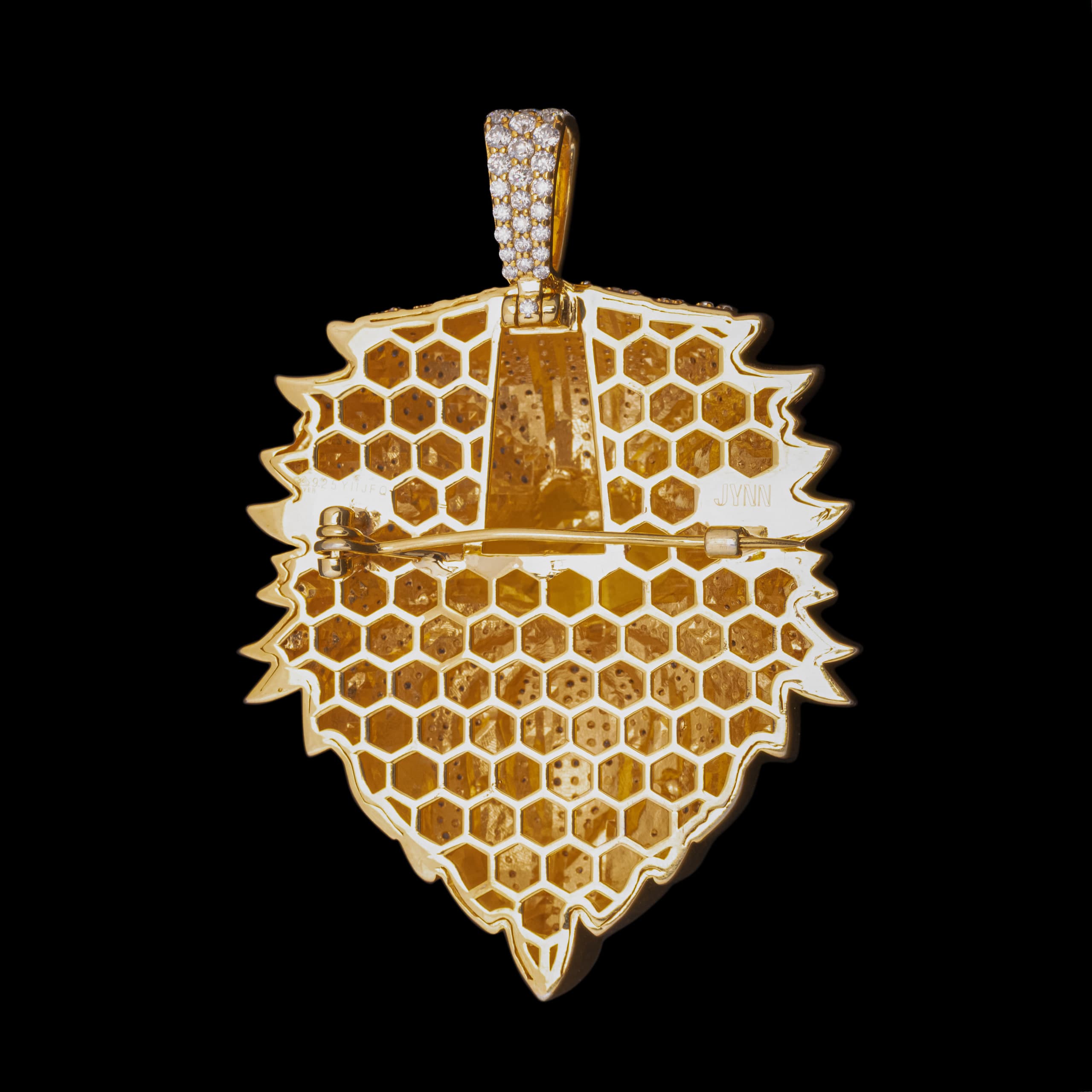 Gold shield pendant filled with a honeycomb lattice